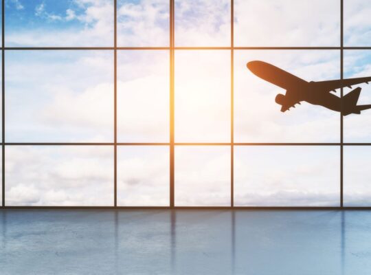 Flugzeug startet am Flughafen Nürnberg, Blick durch große Terminalfenster – Parken Flughafen Nürnberg leicht gemacht.