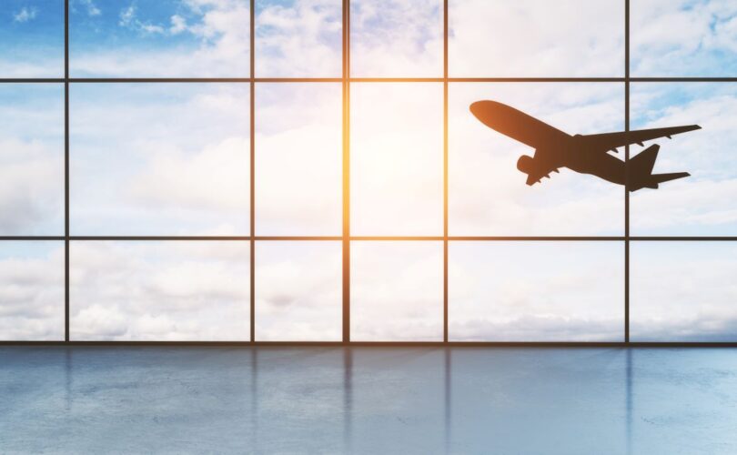 Flugzeug startet am Flughafen Nürnberg, Blick durch große Terminalfenster – Parken Flughafen Nürnberg leicht gemacht.